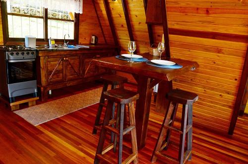 eine Küche mit einem Holztisch und 2 Hockern in der Unterkunft Cabana Montana in Picada Cafe