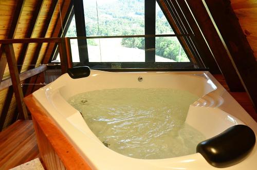 eine Badewanne in einem Zimmer mit Fenster in der Unterkunft Cabana Montana in Picada Cafe