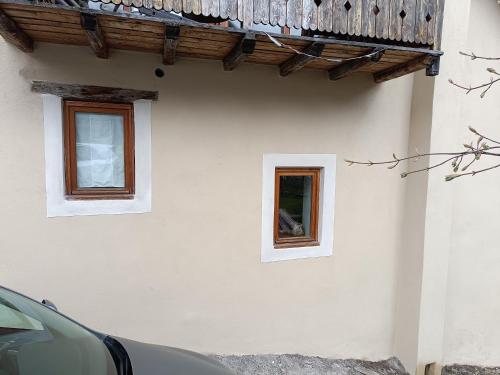 - un bâtiment blanc avec deux fenêtres et un balcon dans l'établissement Landrosace, au Monêtier-les-Bains