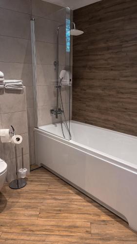 a bathroom with a bath tub and a toilet at Nicolas Resort Club in Kyiv