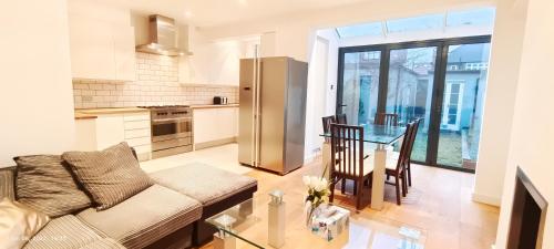 a kitchen and living room with a couch and a table at Park View Garden in London