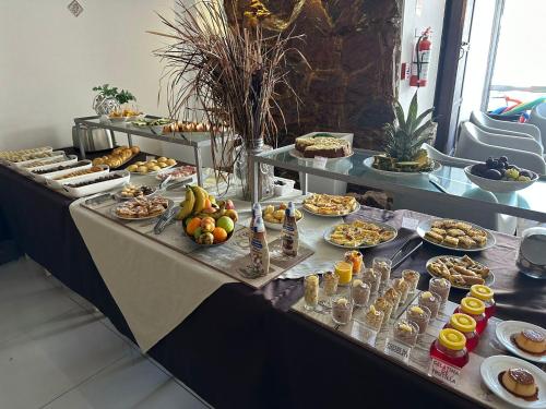 a buffet line with many different types of food at Hotel Lujan in Piriápolis