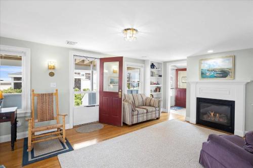 a living room with a fireplace and a chair at Glades Manor: Minot Beach Scituate in Scituate