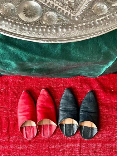 a pair of shoes sitting on a red carpet at Riad Tizwa Marrakech in Marrakech