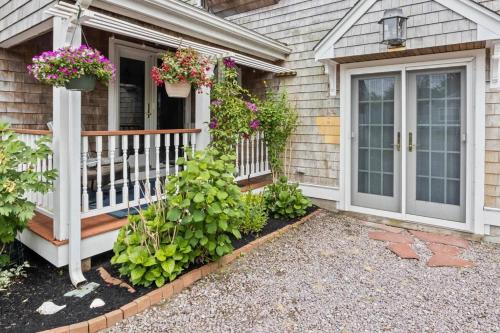 a house with a porch with potted plants on it at A Wave from it All: Swift's Beach Wareham in Wareham