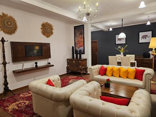 a living room with two couches and a tv at Covanro Sigiriya - Brand New Luxury Hotel in Sigiriya