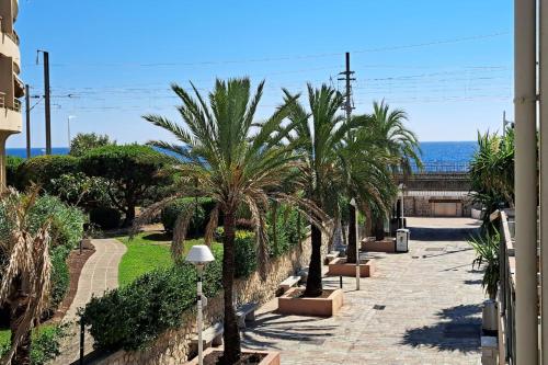 une rangée de palmiers au bord de l'océan dans l'établissement CLOSE SEA - Terrace with Sea View AC and Parking - BENAKEY, à Cannes