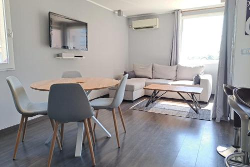 un salon avec une table et un canapé dans l'établissement CLOSE SEA - Terrace with Sea View AC and Parking - BENAKEY, à Cannes