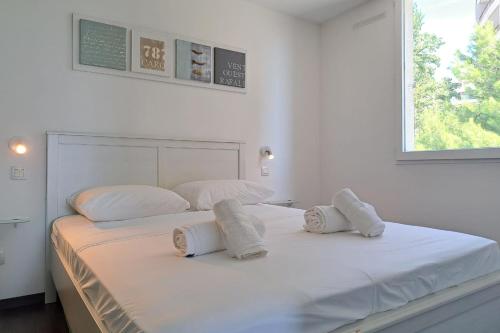 une chambre blanche avec deux lits avec des serviettes dessus dans l'établissement CLOSE SEA - Terrace with Sea View AC and Parking - BENAKEY, à Cannes