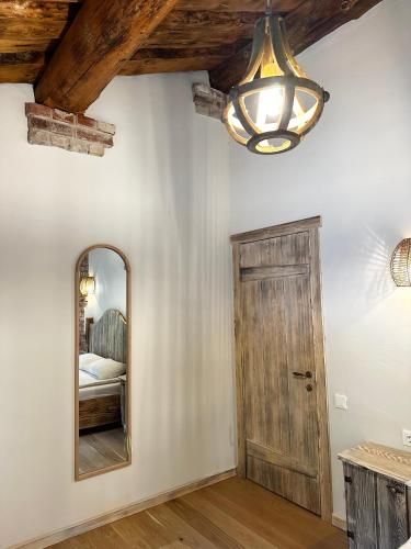 a bedroom with a mirror and a chandelier at Dabintos slėnis in Sumiliszki
