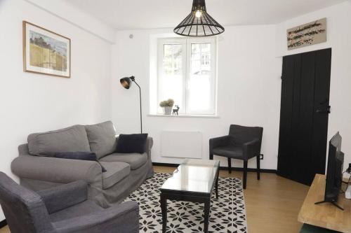 sala de estar con sofá y silla en Appartement Le Moulin by La Boîte En Plus, en Senlis