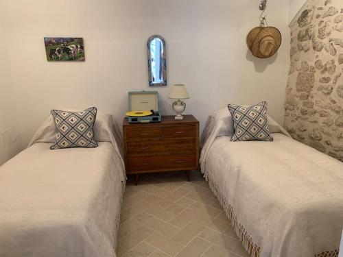 Cette chambre comprend deux lits et une commode avec une fenêtre. dans l'établissement Casa di Carolina Italian Holiday Home, à Pacentro