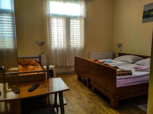 a bedroom with a bed and a desk and a table at Vila Mon Repos in Soko Banja