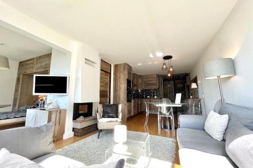 a living room with a couch and a tv at Beautiful 50m with a superb view of Megève in Megève