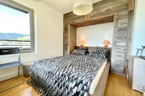 a bedroom with a large bed with a wooden wall at Beautiful 50m with a superb view of Megève in Megève