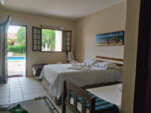 a bedroom with a large bed and a window at Pousada Águas de Serrambi in Porto De Galinhas