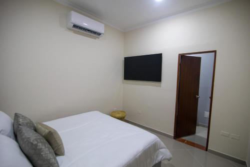 Casa Palmar Cartagena في كارتاهينا دي اندياس: غرفة نوم بيضاء مع سرير وتلفزيون