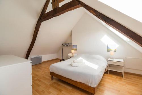 - une chambre mansardée avec un lit blanc dans l'établissement Parenthèse Verte - petite maison à Guingamp, à Guingamp