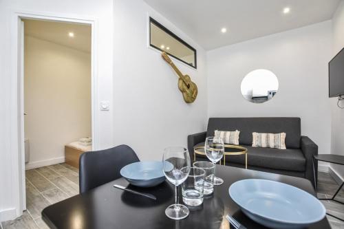 une salle à manger avec une table et des verres à vin dans l'établissement Cosy apartment - 1BR-4P - Auteuil, à Paris