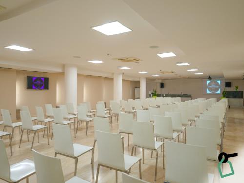 an empty room with white chairs and a podium at HOTIDAY Room Collection - Pisa in Pisa