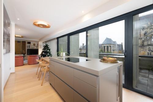 a kitchen with a large window with a view of the city at Les Suites 7 Anges - Parking, Vue Cathédrale & Centre Historique Reims in Reims