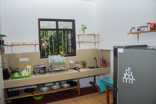 cocina con encimera, ventana y fregadero en Cliff house en Weligama