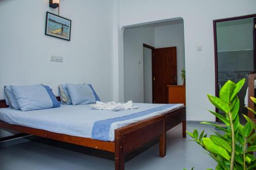 a bedroom with a bed with blue sheets and a mirror at Cliff house in Weligama
