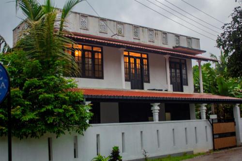 a house with a white fence in front of it at Cliff house in Weligama