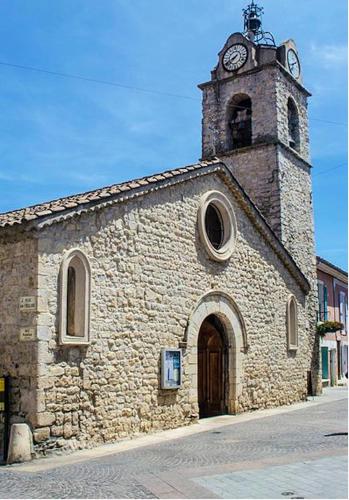 une ancienne église en pierre avec une tour d'horloge dans l'établissement Studio douillet à Gréoux-les-Bains - 30 m² - Terrasse, à Gréoux-les-Bains