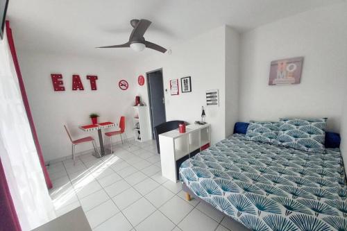 une chambre avec un lit, une table et une chaise dans l'établissement studio costieres climatisé parking gratuit lave linge loggia, à Nîmes