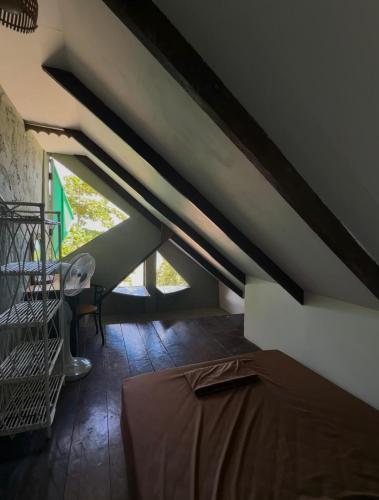 a attic room with a bed and a staircase at Seashell Guesthouse, bar and tattoos in Koh Rong Sanloem