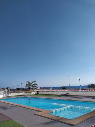 a swimming pool in a resort with the ocean in the background at Departamento vista al mar in Arica