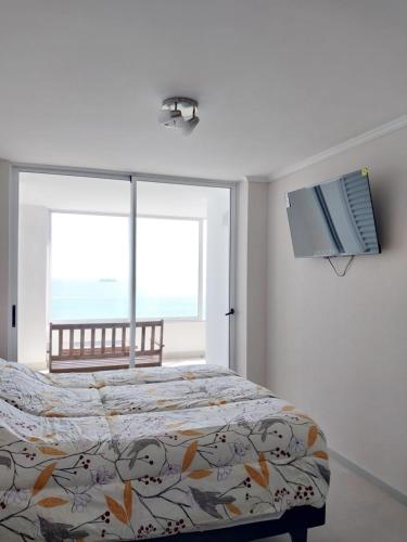 a bedroom with a bed and a large window at Departamento vista al mar in Arica