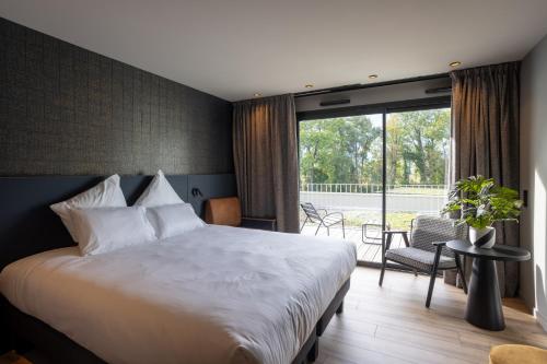 VoglansにあるMiuraの大きなベッドとパティオが備わるホテルルームです。