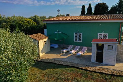une maison avec deux chaises et un bâtiment vert dans l'établissement Cacciatrici di orizzonti casa vacanze, à Lanuvio
