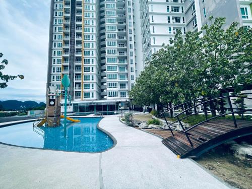 une piscine avec un banc et un bâtiment dans l'établissement Ipoh D Festivo Suites 6-10pax 10mins to Sunway Tambun by IWH, à Ipoh