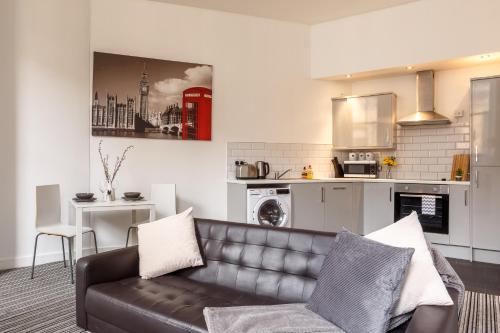 a living room with a couch and a kitchen at Smart Living Apartments - One Beds in Bradford