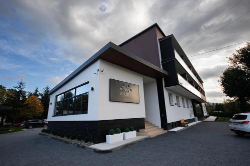 a building with a car parked in front of it at WRZOS resort & wellness in Węgierska Górka