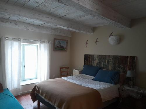 een slaapkamer met een groot bed met blauwe kussens bij Les Vacances in Passy