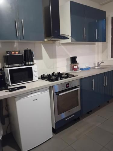 a kitchen with blue cabinets and a stove top oven at une maison en ville in Saint-Denis