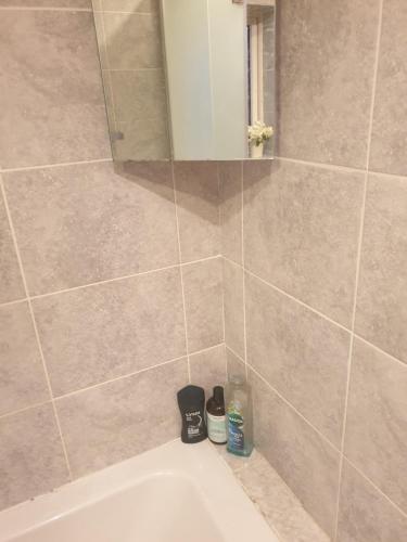 y baño con ducha, lavabo y espejo. en Harry Potter theme Double room in shared house en Garston