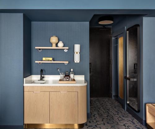 a bathroom with a sink and a blue wall at Kimpton Theta New York - Times Square by IHG in New York