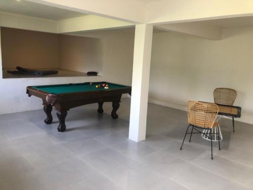 a room with a pool table and two chairs at ELOMY VILLA in Albion