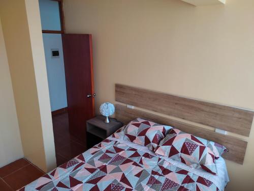 a bedroom with a bed with a colorful quilt at I - Apartamento QOSQO in Cusco