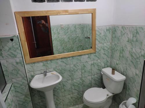 a bathroom with a toilet and a sink and a mirror at I - Apartamento QOSQO in Cusco