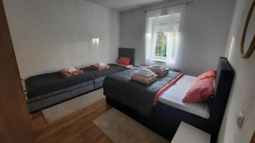 1 dormitorio con 2 camas y ventana en 7 Kućica, en Livno