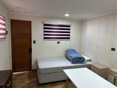 Cette petite chambre comprend un lit et une fenêtre. dans l'établissement Hospedaje CYR, à Temuco