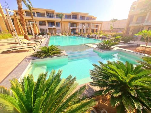 uma grande piscina com palmeiras em frente a um edifício em Gcribs Elgouna em Hurghada