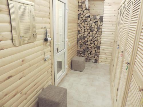 ein Bad mit Holzwänden und einer ebenerdigen Dusche in der Unterkunft Breeze Hotel in Odessa