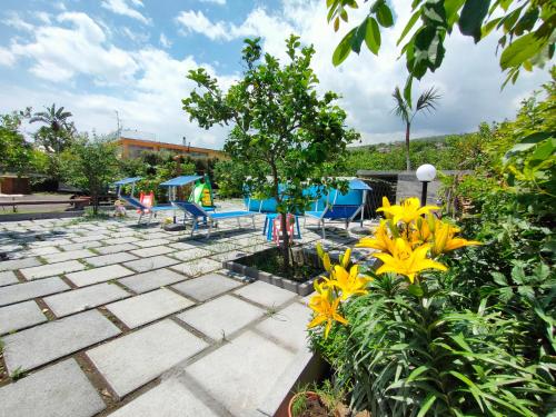 a patio with tables and chairs and yellow flowers at Il Limoneto di Leo in Mascali